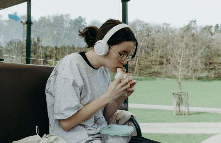 Ragazza mangia mentre ascolta musica