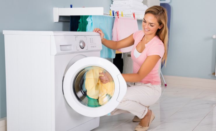 donna con bucato in lavatrice 