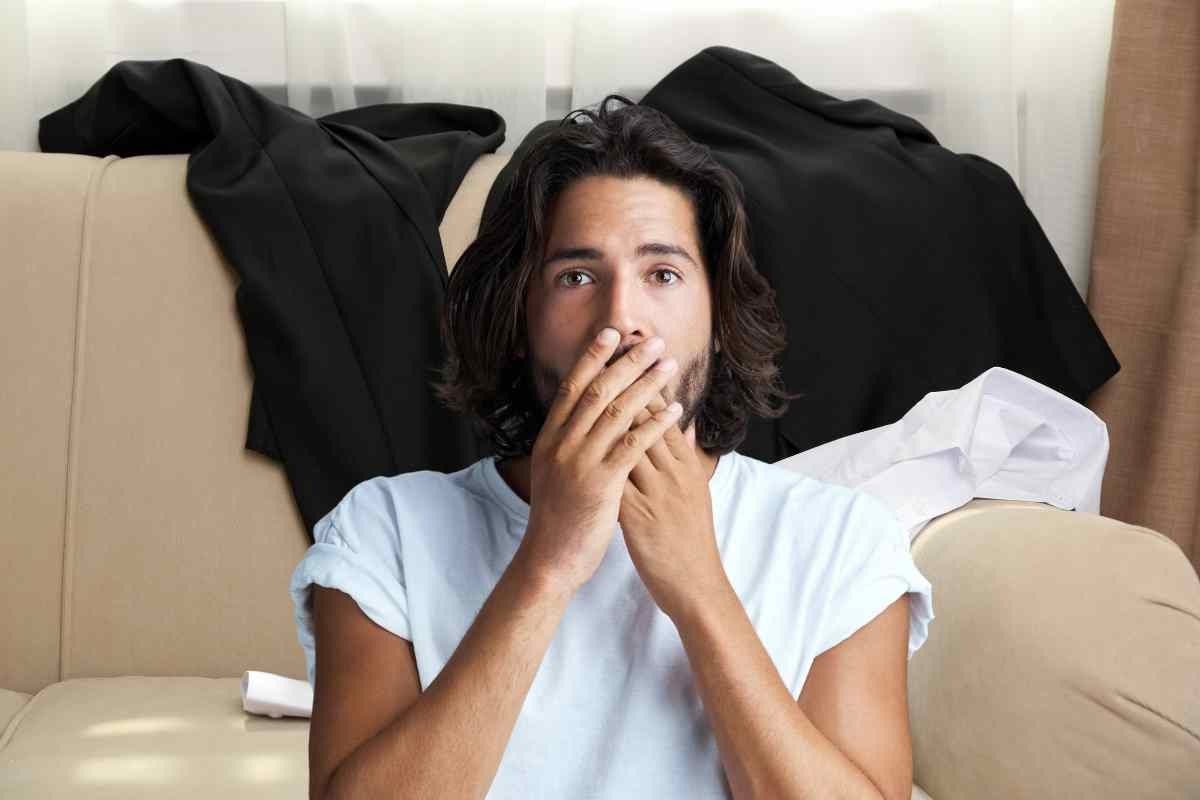 Uomo con mani davanti la bocca
