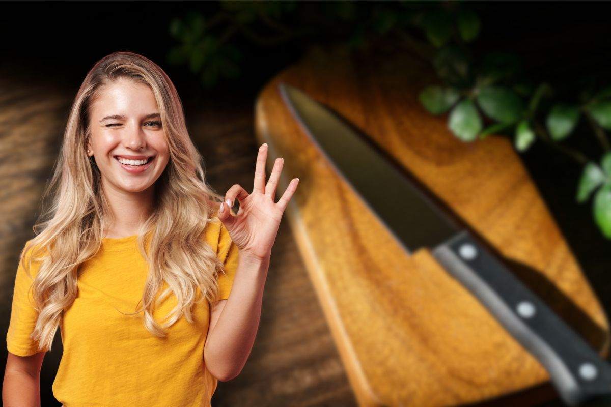 tagliere di legno con coltello e donna sorridente che fa ok con le mani