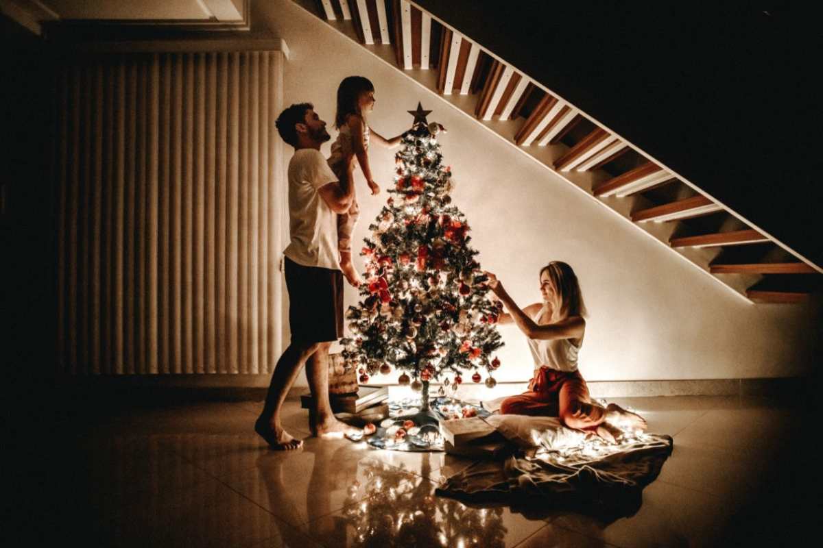 famiglia che prepara albero di Natale