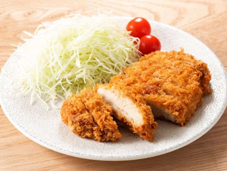 cotoletta nel piatto con insalata e pomodorini