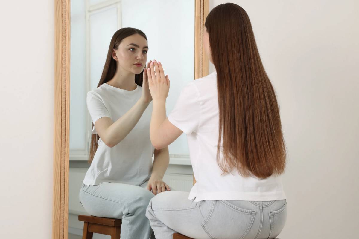 Una donna che guarda la sua immagine allo specchio
