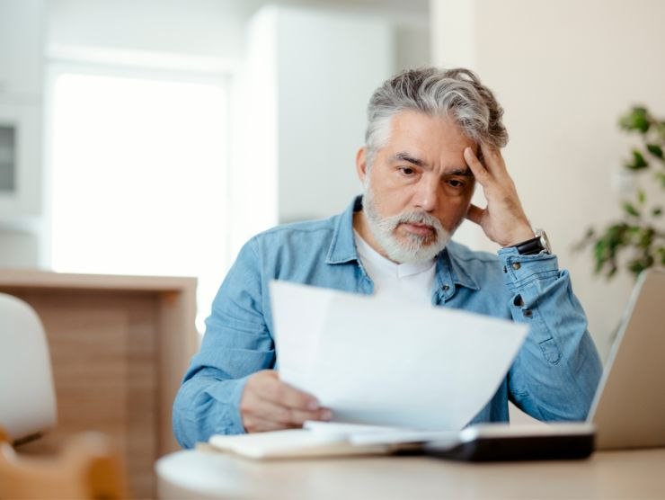 uomo perplesso che legge un foglio