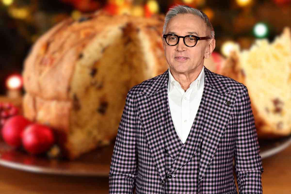Bruno Barbieri vestito con un completo su uno sfondo con panettone