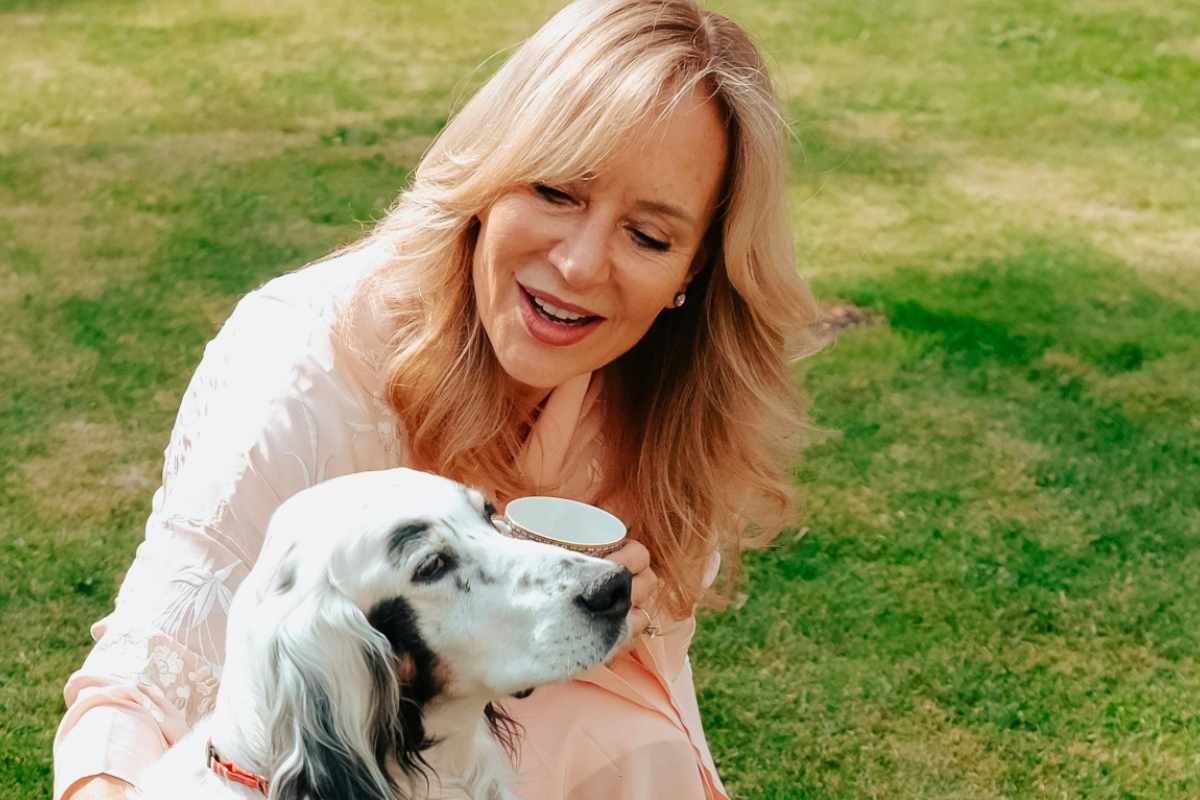 Una donna bionda in un parco con un cane