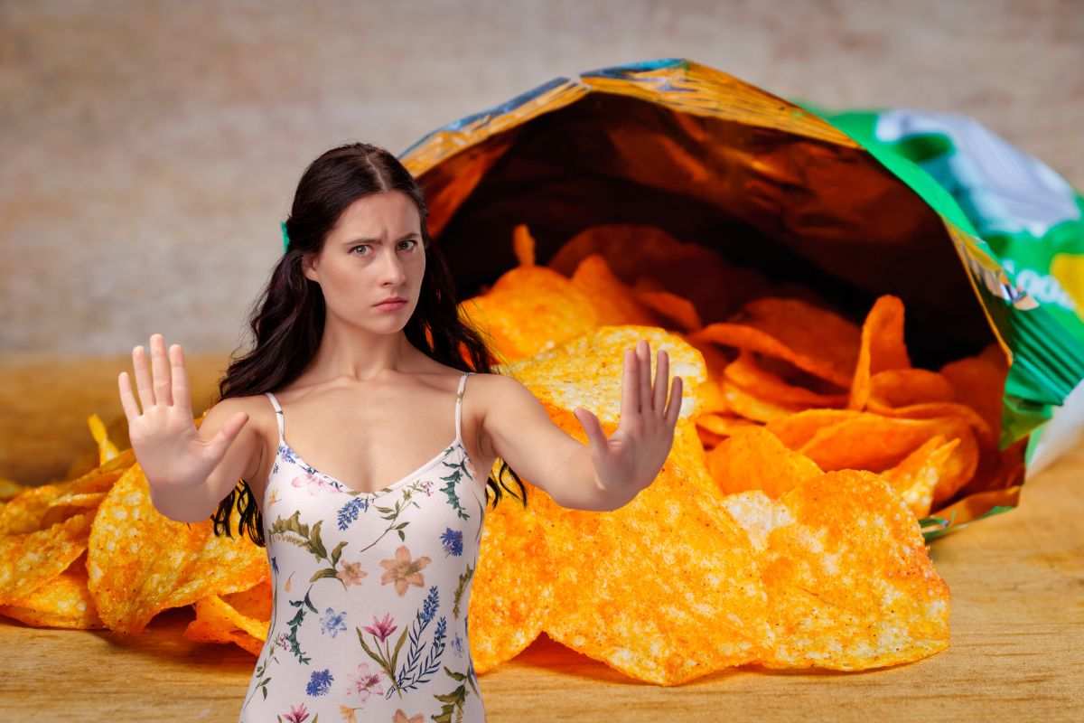 donna che dice no ad un pacchetto di patatine aperto