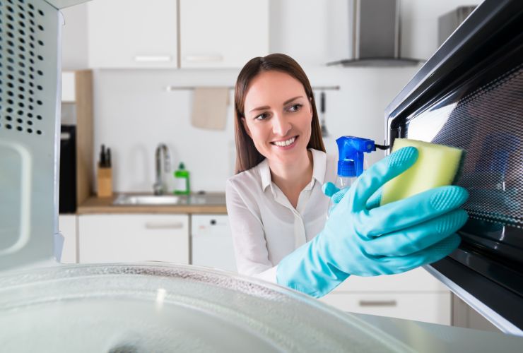 donna che pulisce microonde