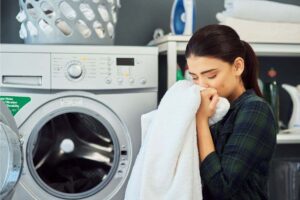 donna che annusa bucato appena tolto dalla lavatrice