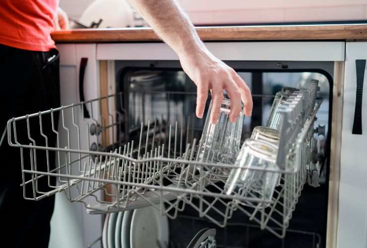 dona mette bicchieri in lavastoviglie