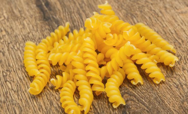 Manciata di fusilli crudi su piano di lavoro